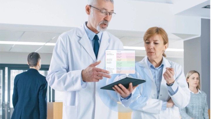 Doctors with ipad talking about capacity management in Alberta hospitals