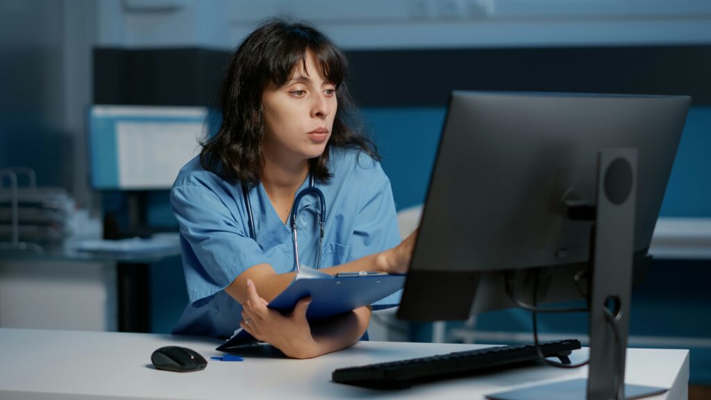 A female doctor reviews information on her computer at a hospital.